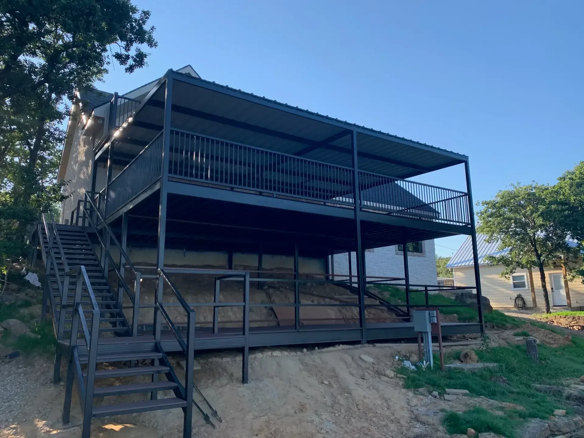 large balcony and porch hanging off a hill attached to a barndo
